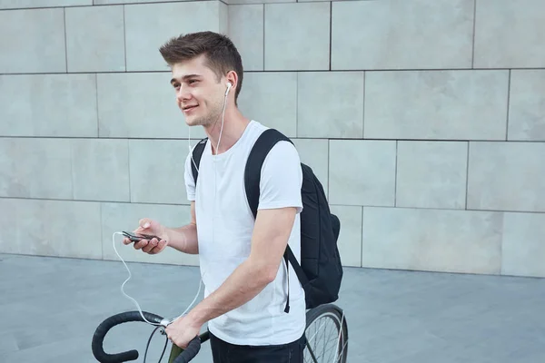 Bonito hipster homem posando com bicicleta na cidade . — Fotografia de Stock