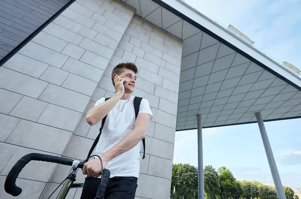 Şehirde bisiklet ile poz yakışıklı hipster adam.