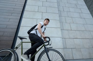 Şehirde bisiklet ile poz yakışıklı hipster adam.