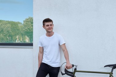 Şehirde bisiklet ile poz yakışıklı hipster adam.