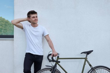 Şehirde bisiklet ile poz yakışıklı hipster adam.