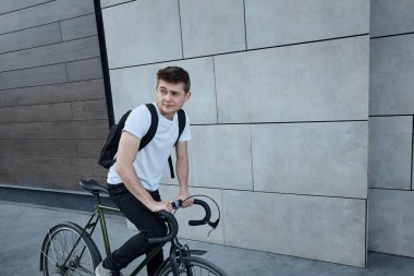 Şehirde bisiklet ile poz yakışıklı hipster adam.