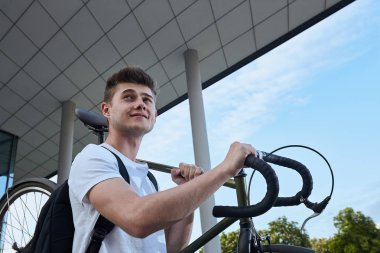 Şehirde bisiklet ile poz yakışıklı hipster adam.