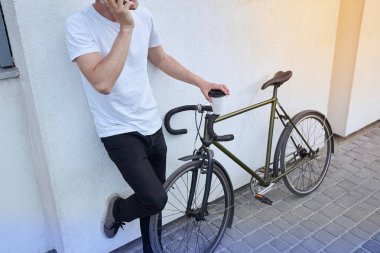 Şehirde bisiklet ile poz yakışıklı hipster adam.