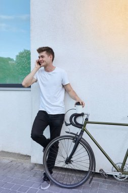 Şehirde bisiklet ile poz yakışıklı hipster adam.