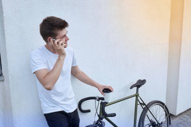 Şehirde bisiklet ile poz yakışıklı hipster adam.