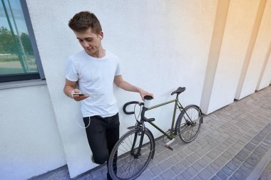 Şehirde bisiklet ile poz yakışıklı hipster adam.