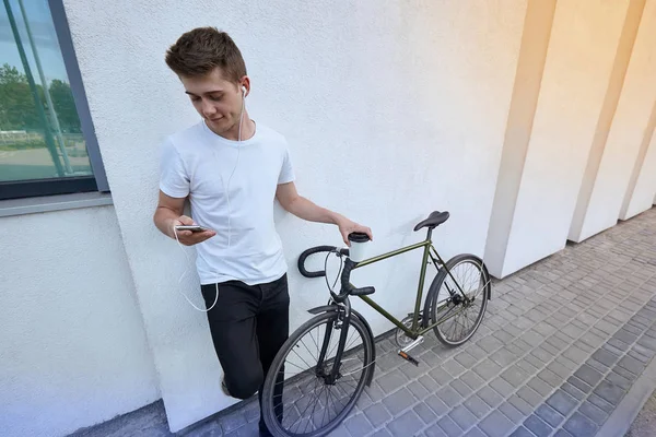 Şehirde bisiklet ile poz yakışıklı hipster adam.