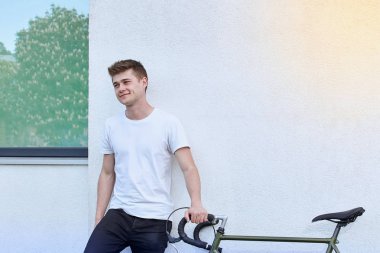 Şehirde bisiklet ile poz yakışıklı hipster adam.