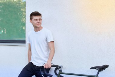 Şehirde bisiklet ile poz yakışıklı hipster adam.