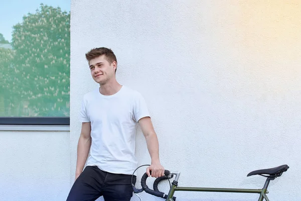 Şehirde bisiklet ile poz yakışıklı hipster adam.
