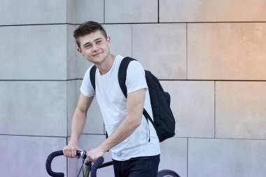 Şehirde bisiklet ile poz yakışıklı hipster adam.