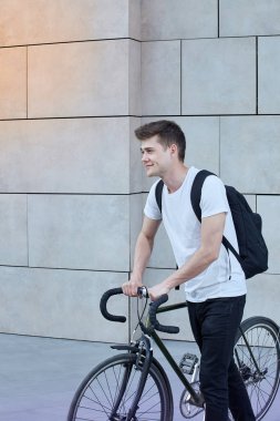 Şehirde bisiklet ile poz yakışıklı hipster adam.