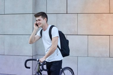 Şehirde bisiklet ile poz yakışıklı hipster adam.