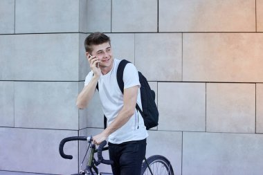 Şehirde bisiklet ile poz yakışıklı hipster adam.