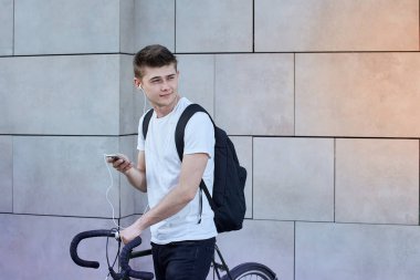 Şehirde bisiklet ile poz yakışıklı hipster adam.