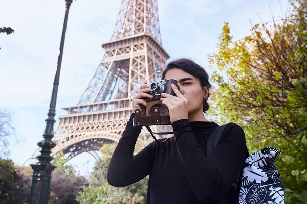 Bella ragazza in posa con una macchina fotografica sullo sfondo della Torre Eiffel. Parigi, Campione di Marte — Foto Stock