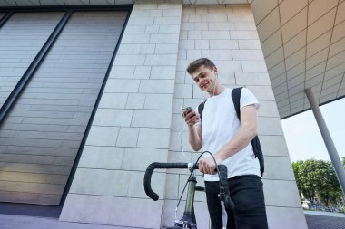 Şehirde bisiklet ile poz yakışıklı hipster adam.