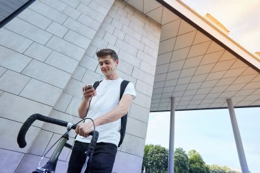 Şehirde bisiklet ile poz yakışıklı hipster adam.