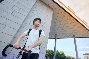 Şehirde bisiklet ile poz yakışıklı hipster adam.