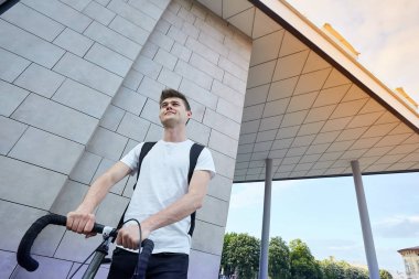 Şehirde bisiklet ile poz yakışıklı hipster adam.