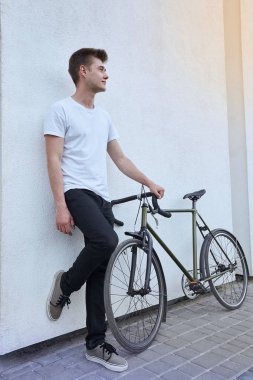 Şehirde bisiklet ile poz yakışıklı hipster adam.