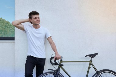 Şehirde bisiklet ile poz yakışıklı hipster adam.