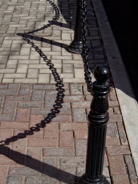 Zincir çit ve kaldırım kutunun üzerindeki gölge