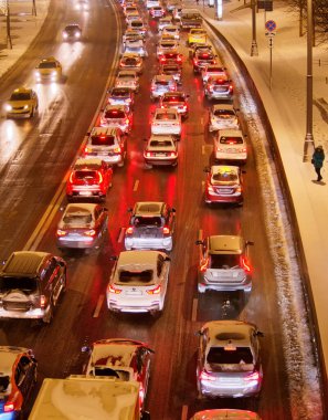 Kış akşamları şehirde caddelerde trafikte duran arabalar.