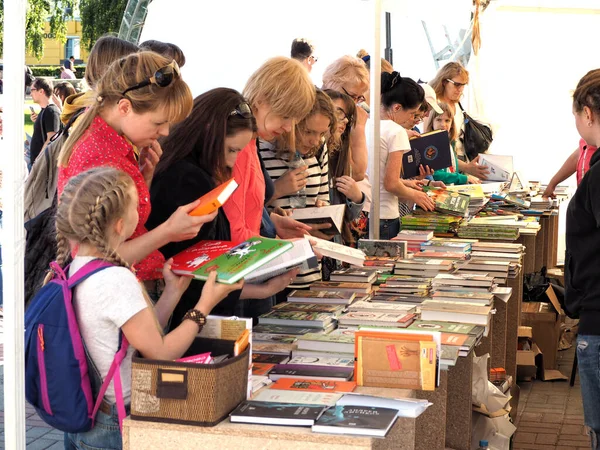 Voronezh, Rusya - 12 Haziran 2016: Kadınlar ve genç bir kız, Kitap Fuarı 'nda kitap tezgahında ellerinde bulunan kitapları inceliyorlar