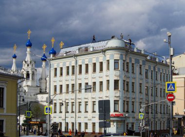 Moskova, Rusya, 1 Temmuz 2017: İşçiler Putinki 'deki İsa' nın Doğumu Kilisesi 'nin yanındaki bir şehir caddesinde çok katlı eski bir binanın çatısını onarıyorlar