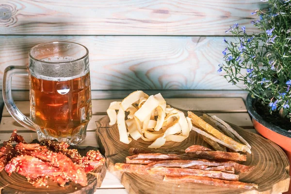 Becher mit Bier und Snacks auf dem Hintergrund einer Ziegelwand auf dem Tisch. Das Konzept der Entspannung, Bars und Partys — Stockfoto