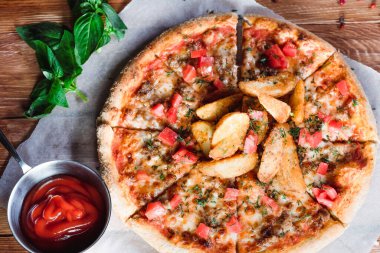 Otlar ve baharatlarla çevrili ahşap bir masada iştah açıcı pizza. Lezzetli yemekler, restoranlar ve kafeler.