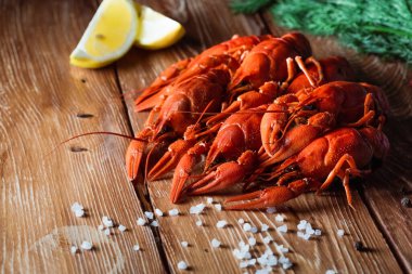 Baharatlar, limon ve dereotunun arasında, ahşap bir masada kaynamış kerevit. Yemek konsepti, bira aperatifleri, bar ve restoranda rahatlama.