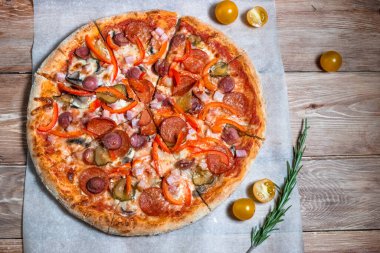 Otlar ve baharatlarla çevrili ahşap bir masada iştah açıcı pizza. Lezzetli yemekler, restoranlar ve kafeler.
