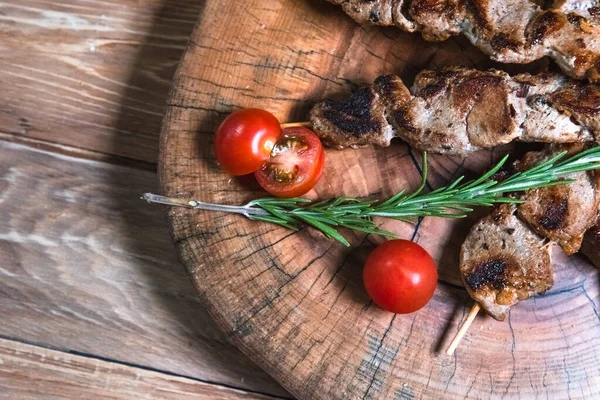 Pedaços apetitosos de carne em espetos em um fundo de madeira. Conceito de comida e serviço — Fotografia de Stock