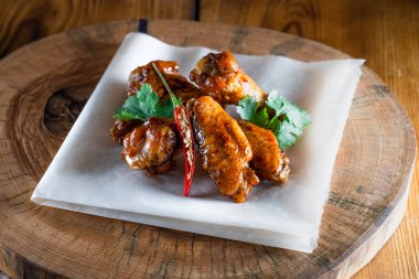 Ahşap tepside soslu tavuk kanadı. Yemek ve servis kavramı, barlarda ve restoranlarda yemek.