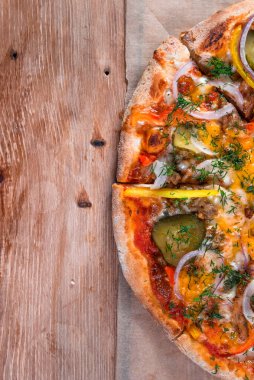 Otlar ve baharatlarla çevrili ahşap bir masada iştah açıcı pizza. Lezzetli yemekler, restoranlar ve kafeler.