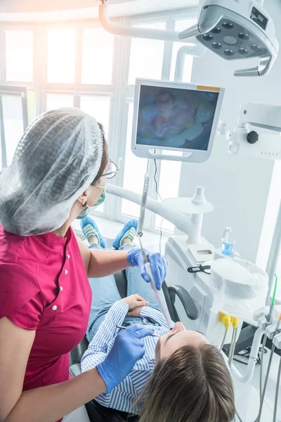 Diş hekimi diş muayenehanesindeki bir hastayı muayene ediyor. Tıp merkezlerinde sağlık ve tedavi kavramı