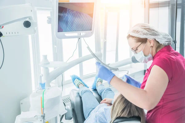 El dentista examina a un paciente en una recepción en el consultorio dental. El concepto de atención y tratamiento de la salud en las instalaciones médicas — Foto de Stock