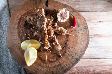 Ahşap bir arka planda şiş üzerinde iştah açıcı et parçaları. Yemek ve servis konsepti