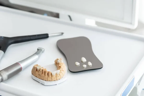 Diş laboratuarındaki çalışma masasında, kaplamalı ve kaplamalı yapay çene. Diş sağlığı ve tedavi kavramı