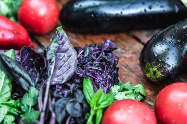 Çiftlik domatesleri, patlıcanlar ve yeşiller ahşap bir yüzeyde bulunur. Biyolojik ürünler, biyolojik ekoloji kavramı, sizin tarafınızdan yetiştirilmiş, vejetaryenler.