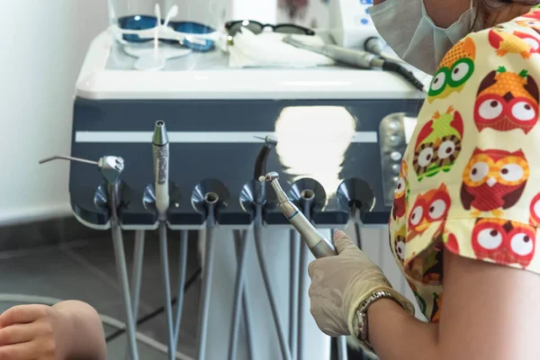 Primer plano de las manos de los médicos con un taladro dental en una clínica dental. Concepto de atención sanitaria y tratamiento — Foto de Stock