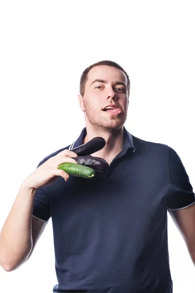 Egy vonzó férfi portréja, aki szürke alapon dobálja a zöldségeket a stúdióba. A helyes táplálkozás fogalma — Stock Fotó