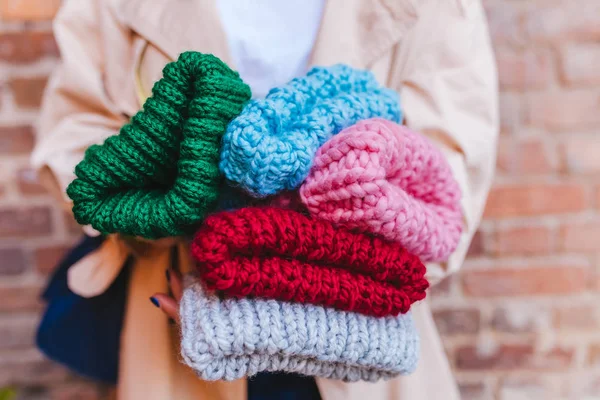 妇女抱着一堆针织温暖的冬帽的近景 — 图库照片