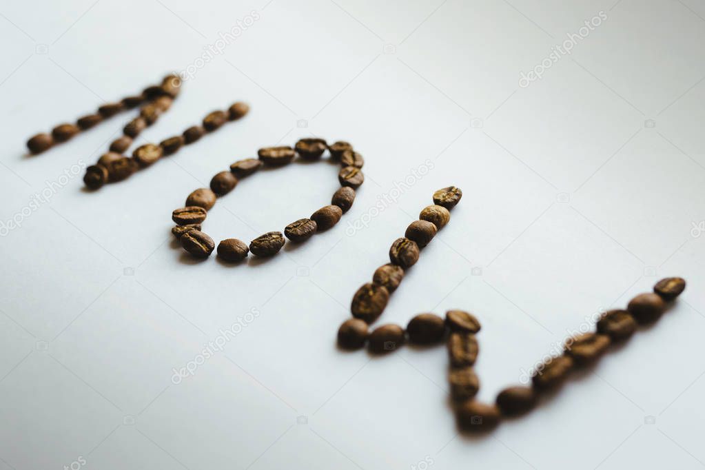 Word NOW made with coffee beans