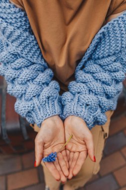 Örme hırka tutan çiçek kadın yakın çekim