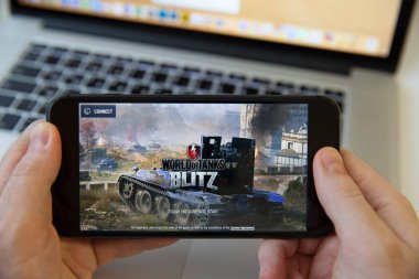Moskova / Rusya - 20 Şubat 2019: bir iphone Macbook arka plan üzerinde tutarak. Tanklar oyunu dünya yüklüyor