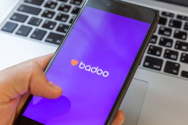 Moskova / Rusya - 10 Mart 2019: el Macbook arka plan üzerinde siyah iphone. Ekran app badoo dating